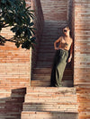 Woman on a terracotta brick staircase under a plumeria tree in Los Cabos