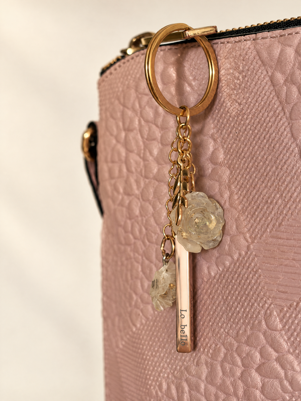Poesía Keyring detail on a bag, pink gold and gold tones